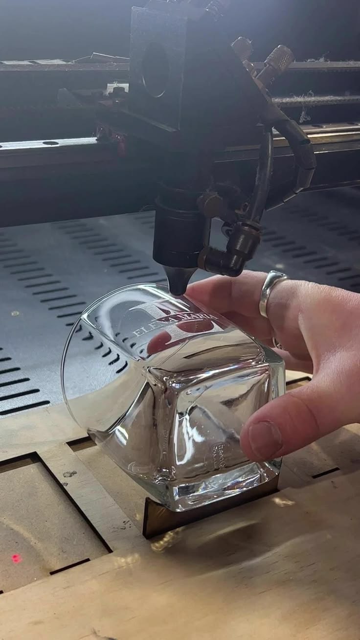 Laser engraving a design onto a glass tumbler in the machine